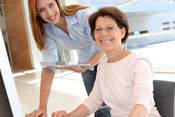 woman helping woman at computer screen